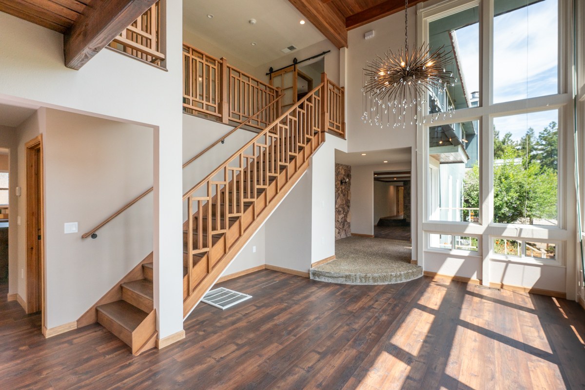 Poplar fire rebuild — staircase with sputnik chandelier and natural sunlight